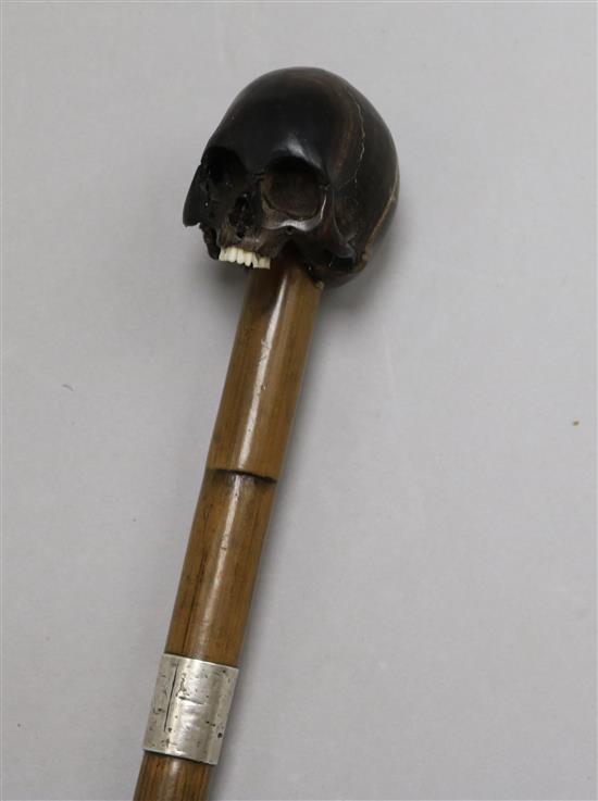 A walking cane with carved ebony handle in shape of human skull length 88cm